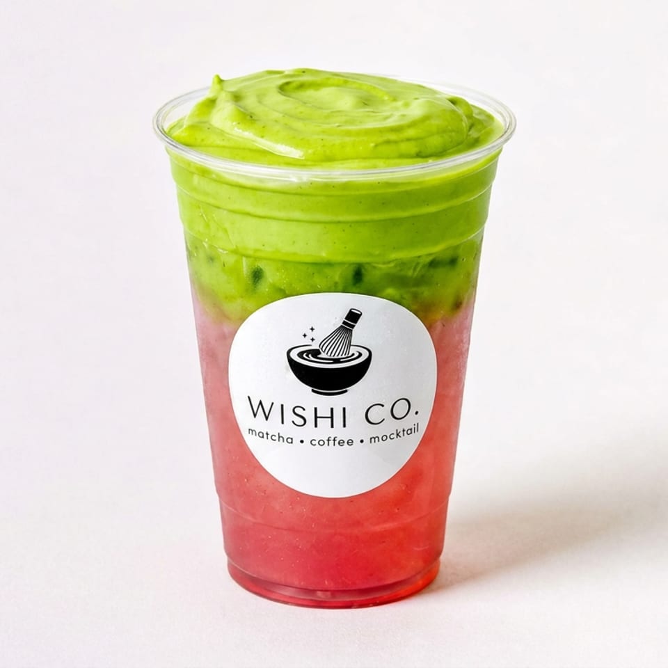 Layered strawberry matcha drink in a clear cup, topped with green matcha foam and labeled WISHI CO.