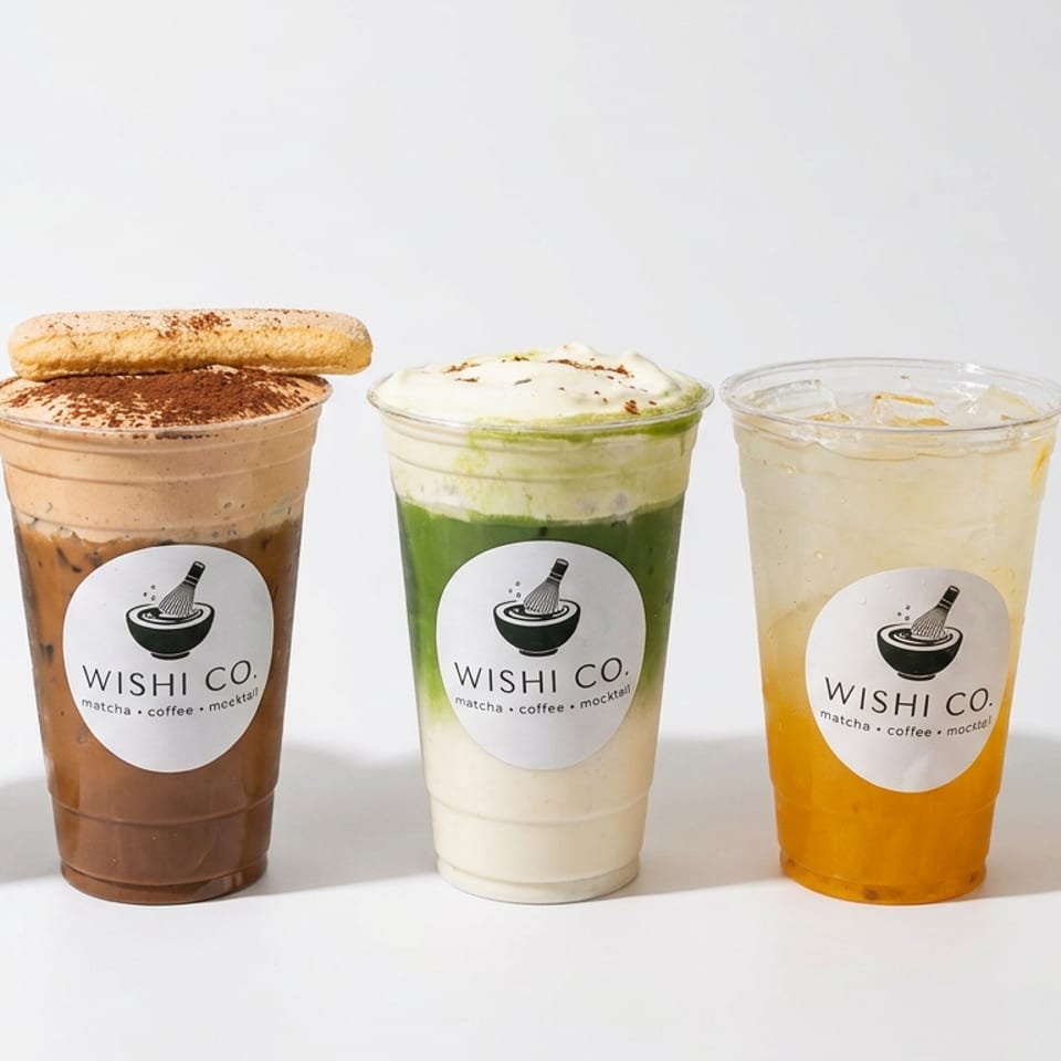 Five WISHI CO. drinks, including layered matcha beverages, a chocolate drink, and an iced orange mocktail, arranged against a white background.